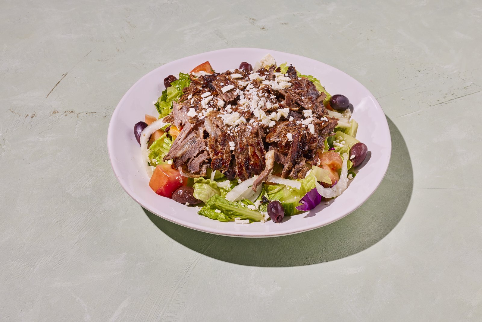 Shawarma salad with romaine, tomato, cucumber, olives and feta