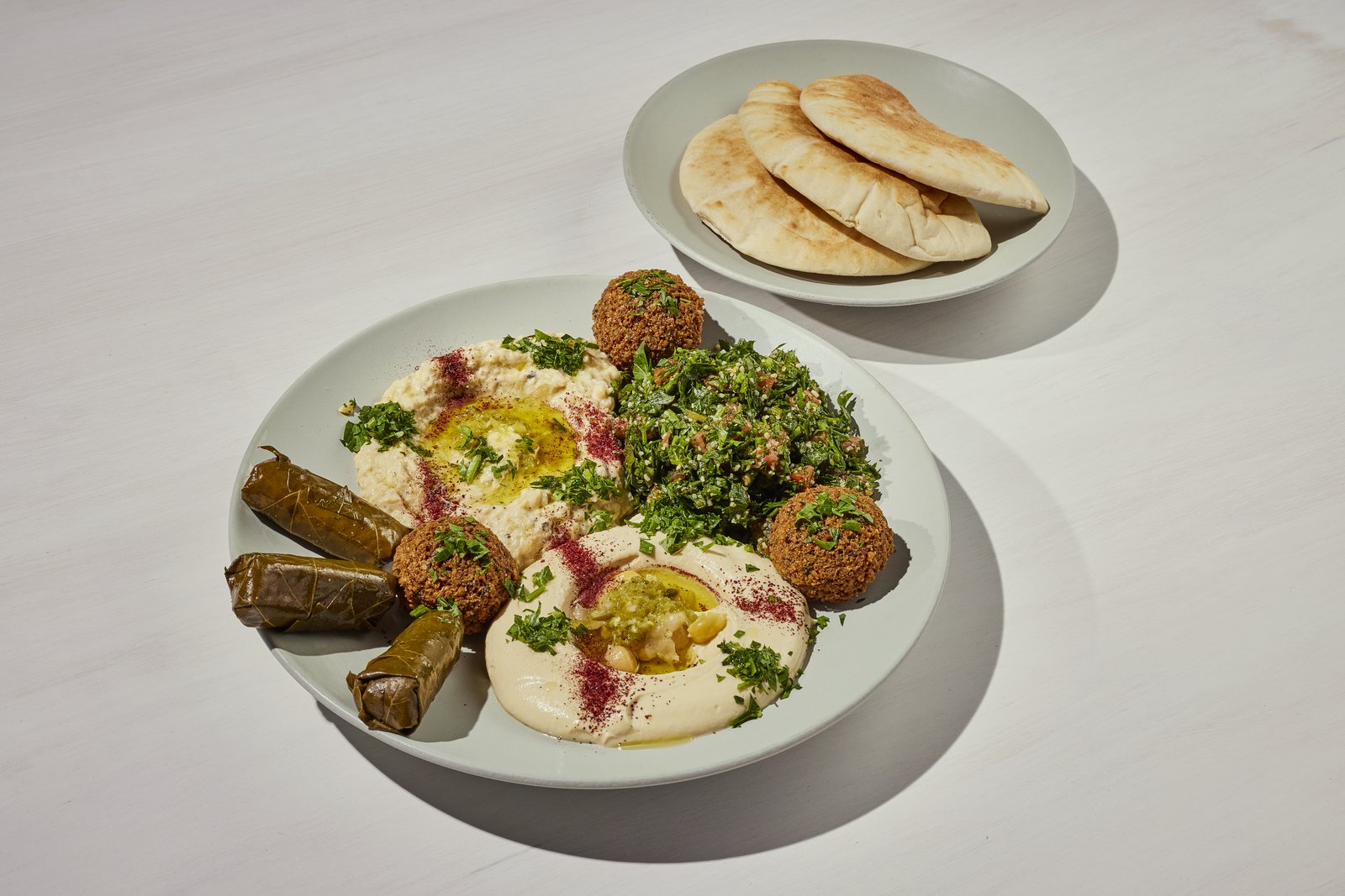 Sinya mezze plate with hummus, baba ghanoush, tabbouleh, falafel and stuffed grape leaves, served with warm pita