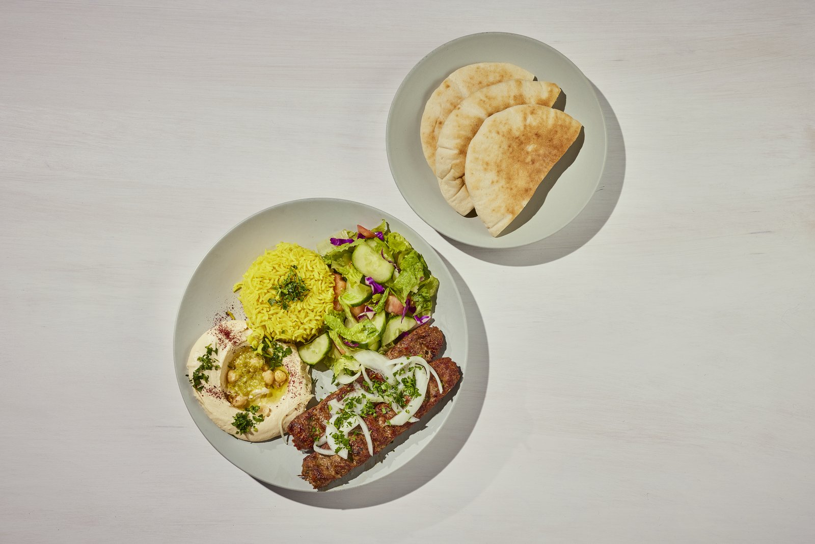 Kafta kabob plate with yellow rice, hummus, garden salad and pita