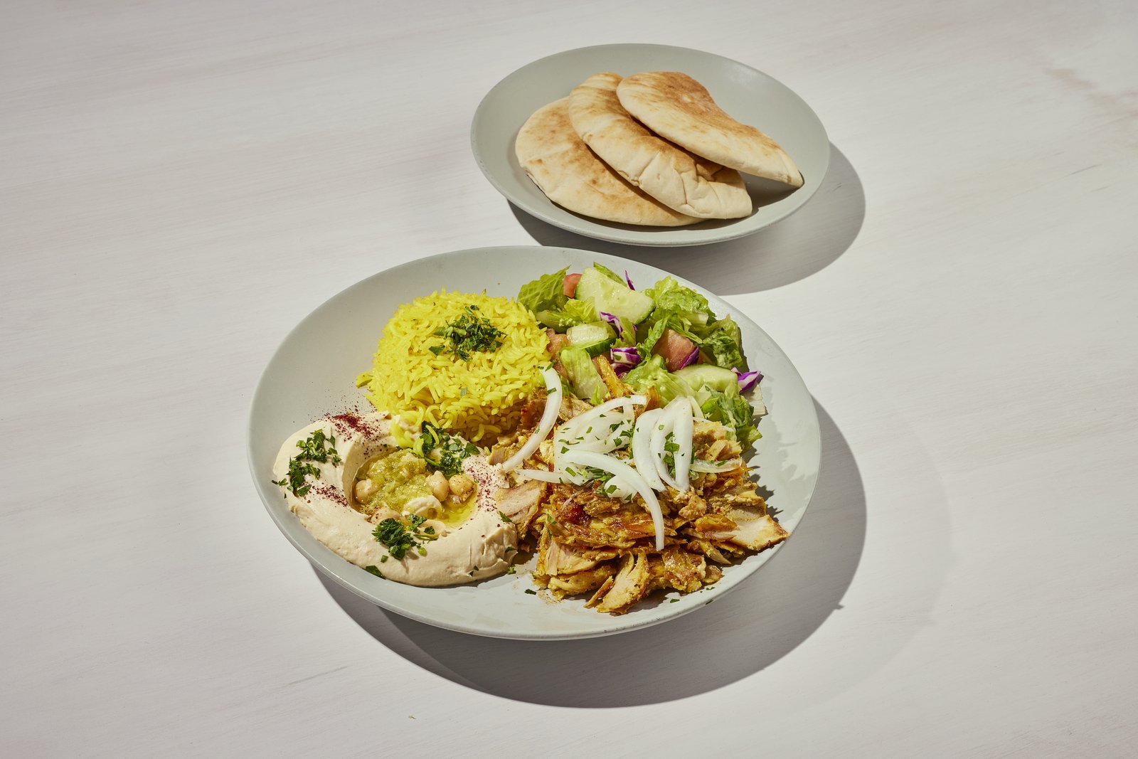Chicken shawarma plate with yellow rice, hummus, salad and pita