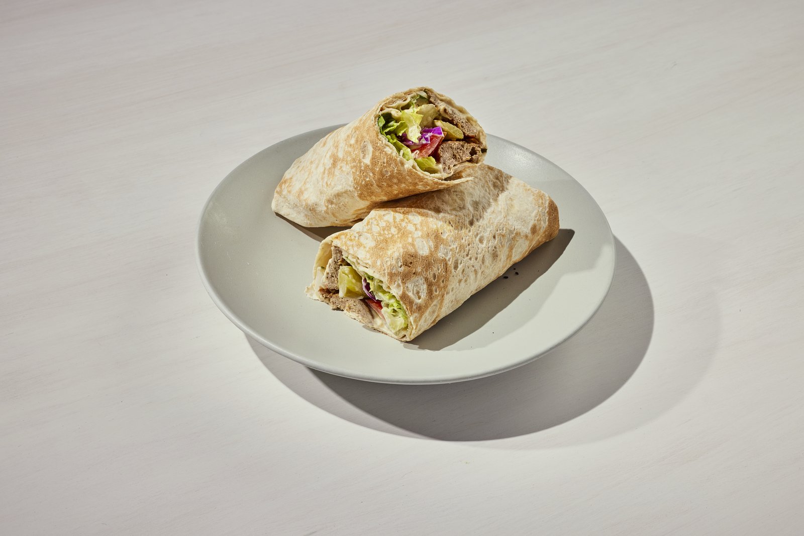 Gyro wrap cut in half on a plate
