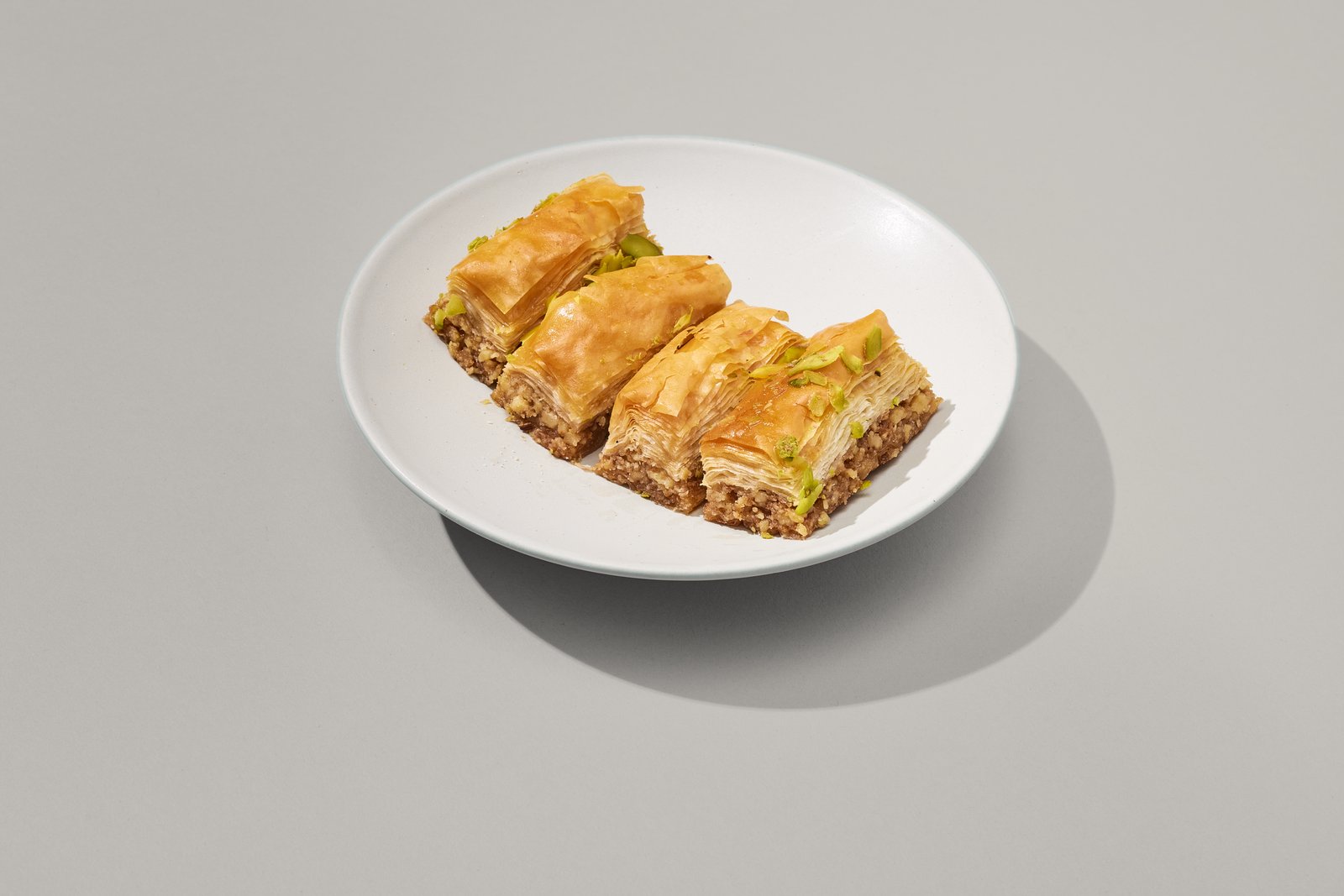 Four pieces of pistachio baklava on a plate